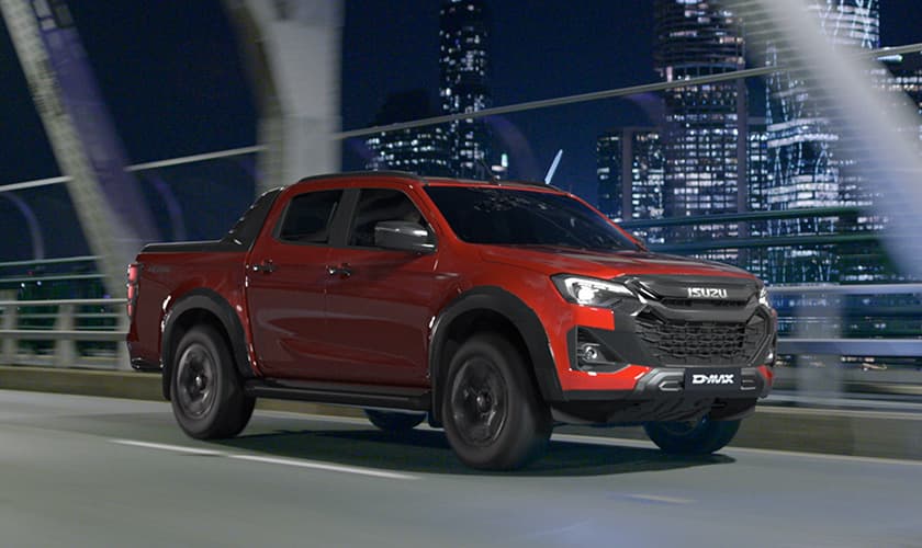 Isuzu Ute driving on a bridge with a city skyline in the background